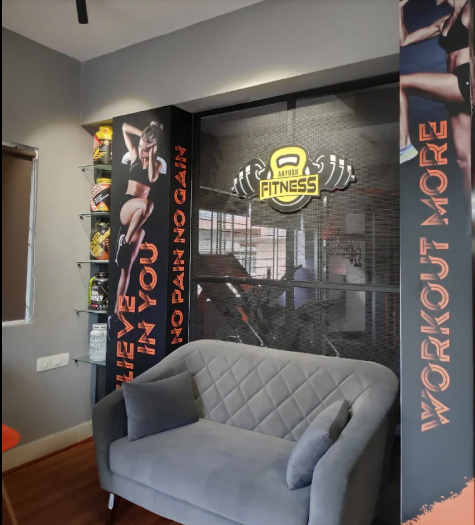 Member lounge with supplement shelf and Aayush Fitness signage